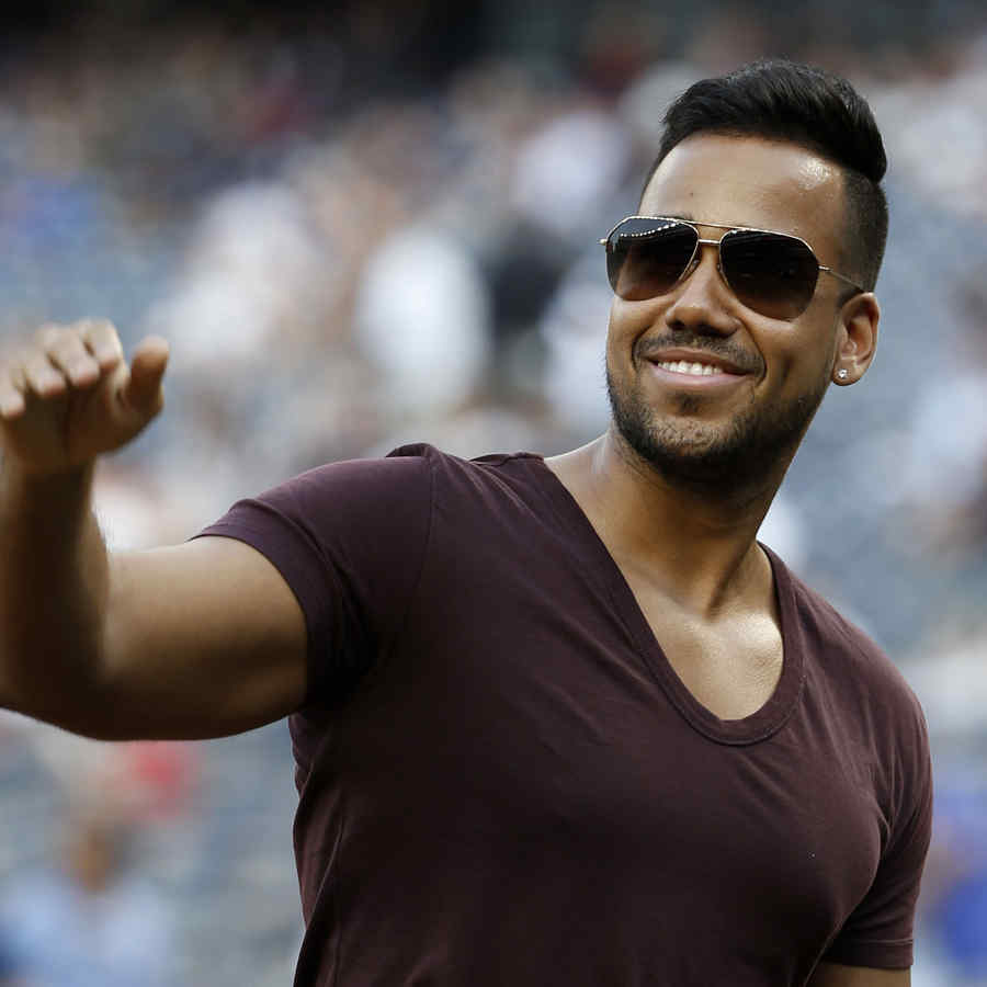 FILE - In this July 1, 2014 file photo, singer Romeo Santos, known as the "King of Bachata," waves to fans during a pre-game ceremony before a baseball game at Yankee Stadium in New York. Santos is nominated in 10 categories for next year's Premio Lo Nuestro music awards to be held Feb. 19, 2015. (AP Photo/Kathy Willens, File)